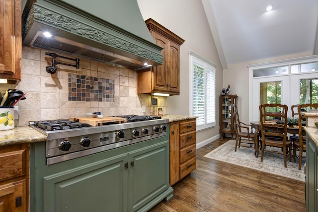 kitchen featuring stainless steel gas stovetop, lofted ceiling with beams, tasteful backsplash, custom exhaust hood, and dark wood-style flooring