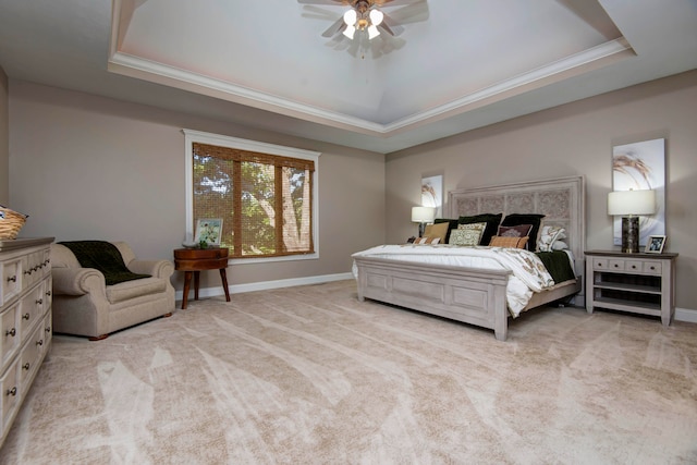 carpeted bedroom with a raised ceiling, ornamental molding, and ceiling fan