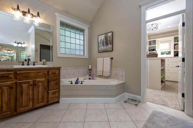 full bathroom featuring a bath, tile patterned floors, vaulted ceiling, baseboards, and vanity