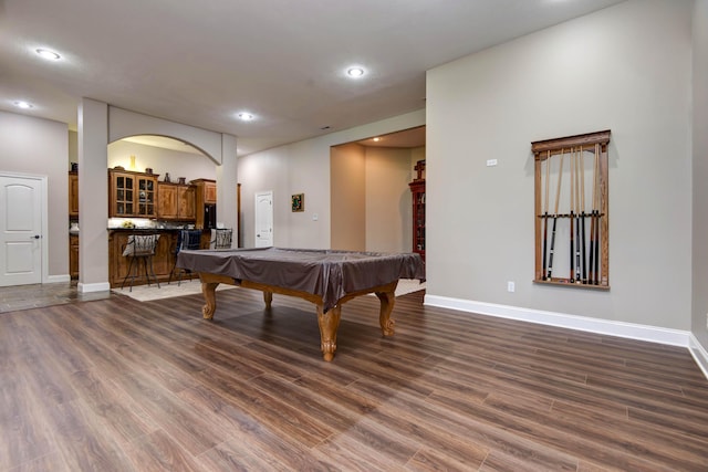 rec room with baseboards and dark wood finished floors