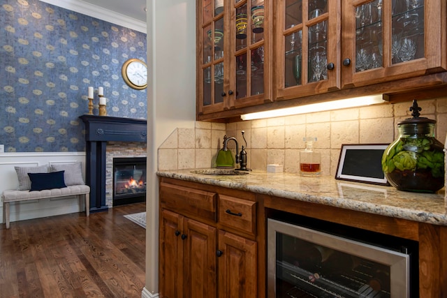 kitchen featuring light stone countertops, sink, dark hardwood / wood-style flooring, ornamental molding, and wine cooler