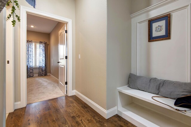 hall featuring baseboards and dark wood-style floors