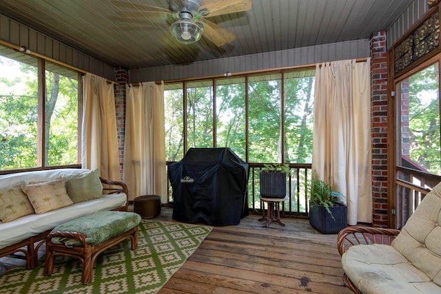 sunroom featuring ceiling fan, wood ceiling, and a healthy amount of sunlight