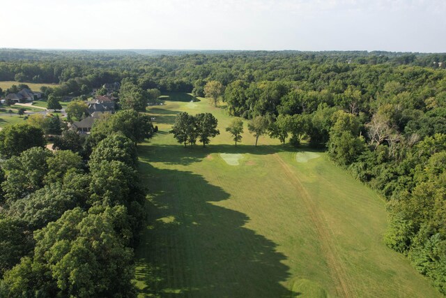 bird's eye view with a wooded view