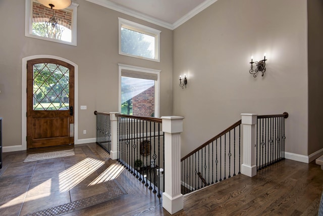 entryway with baseboards, ornamental molding, wood finished floors, and plenty of natural light