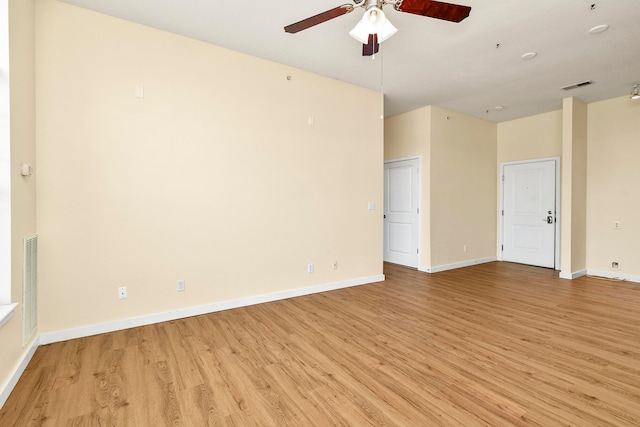 empty room with ceiling fan and light hardwood / wood-style flooring