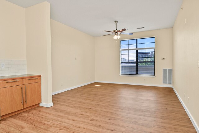 spare room featuring ceiling fan and light hardwood / wood-style flooring