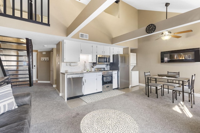 kitchen featuring light colored carpet, white cabinets, and stainless steel appliances