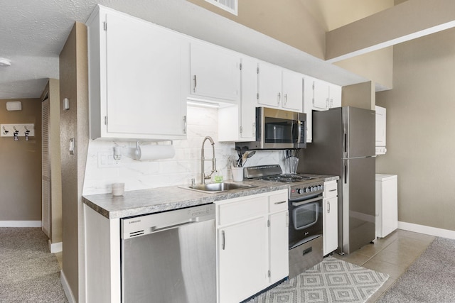 kitchen with sink, tasteful backsplash, a textured ceiling, white cabinetry, and stainless steel appliances