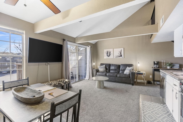 carpeted living room featuring ceiling fan, a wealth of natural light, and vaulted ceiling with beams