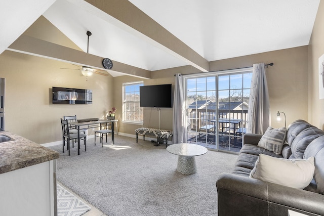 living room featuring ceiling fan, vaulted ceiling with beams, and carpet flooring