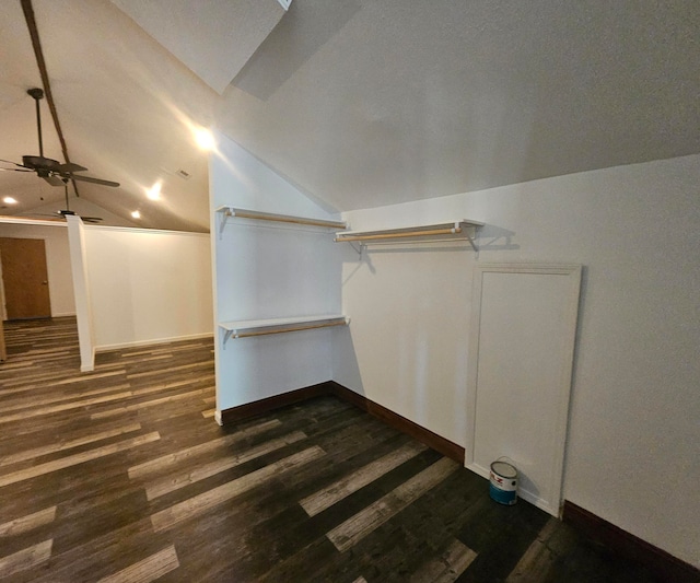 walk in closet with ceiling fan, dark wood-type flooring, and vaulted ceiling