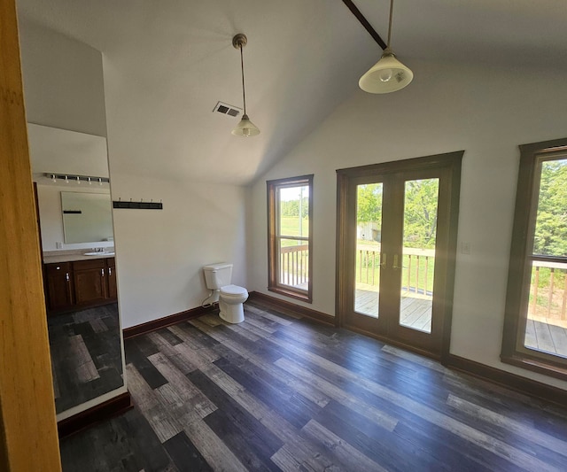 bathroom with hardwood / wood-style floors, a healthy amount of sunlight, vaulted ceiling, and toilet