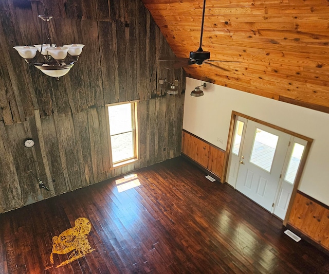 unfurnished living room with wooden walls, dark hardwood / wood-style flooring, high vaulted ceiling, and wooden ceiling