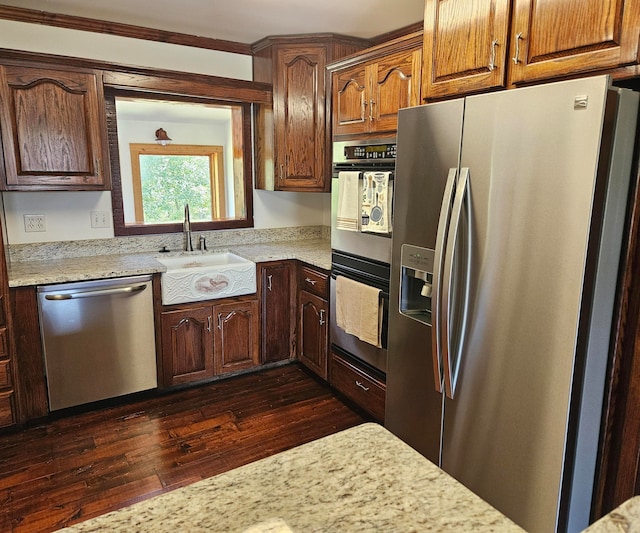 kitchen featuring crown molding, appliances with stainless steel finishes, dark hardwood / wood-style flooring, and sink