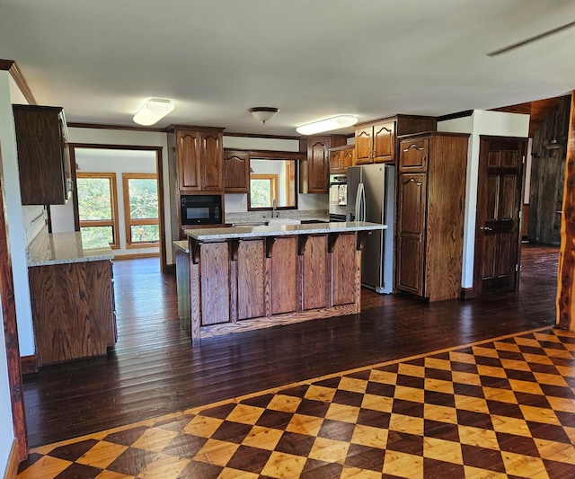 kitchen featuring a center island, dark hardwood / wood-style floors, stainless steel fridge, and a healthy amount of sunlight