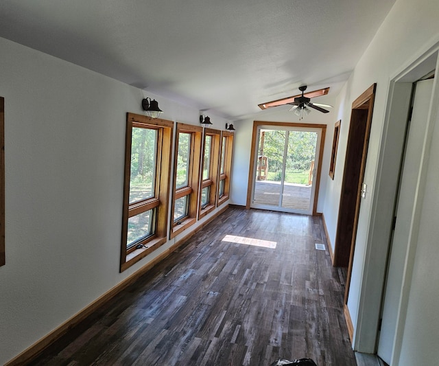 interior space with ceiling fan, dark wood-type flooring, and vaulted ceiling