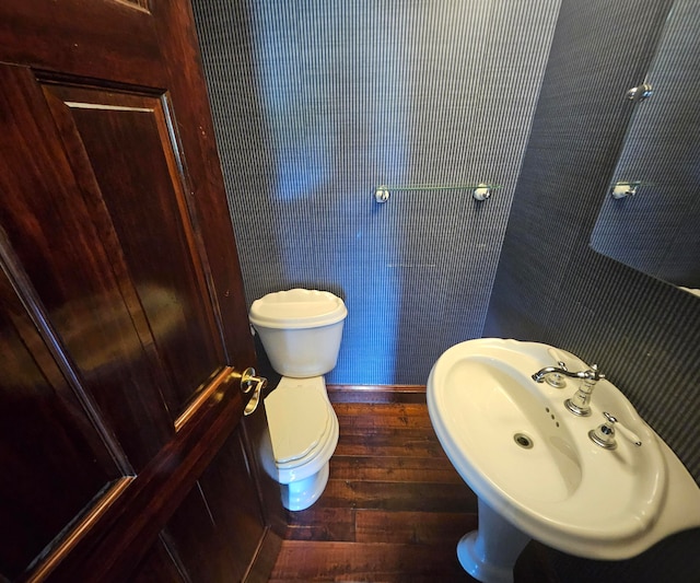 bathroom with wood-type flooring, sink, and toilet