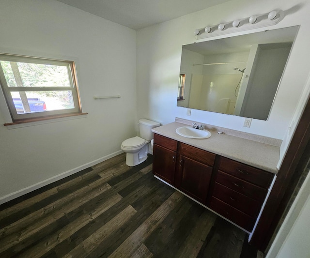 bathroom featuring wood-type flooring, toilet, vanity, and a shower