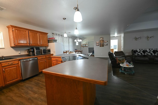 kitchen featuring dark wood-style floors, brown cabinets, dark countertops, appliances with stainless steel finishes, and a kitchen island