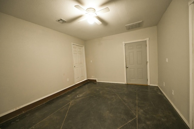 unfurnished room with concrete flooring, visible vents, baseboards, and a ceiling fan