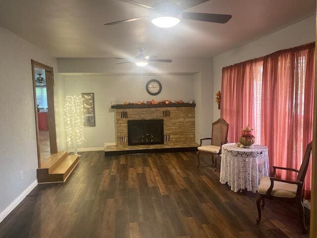 living room featuring ceiling fan, a fireplace, plenty of natural light, and dark hardwood / wood-style flooring