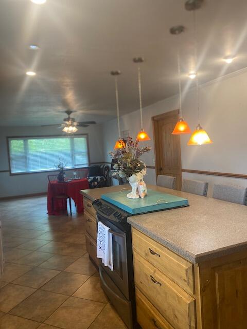 kitchen with ceiling fan, hanging light fixtures, black electric range oven, and dark tile patterned floors