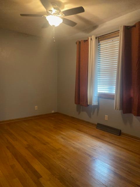 spare room with hardwood / wood-style flooring and ceiling fan