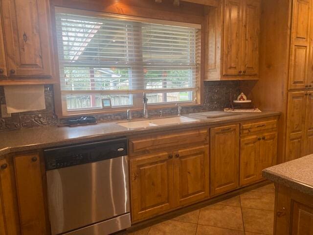 kitchen featuring light tile patterned flooring, sink, decorative backsplash, and stainless steel dishwasher