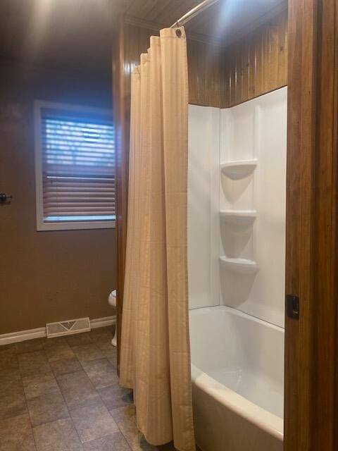 bathroom featuring toilet and shower / bath combo