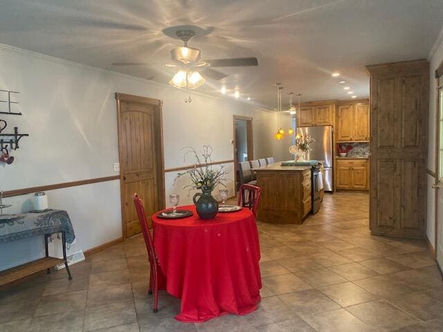 dining space with ceiling fan and ornamental molding