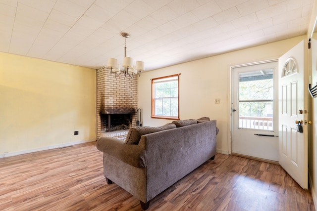 living room featuring a fireplace, hardwood / wood-style floors, and a chandelier