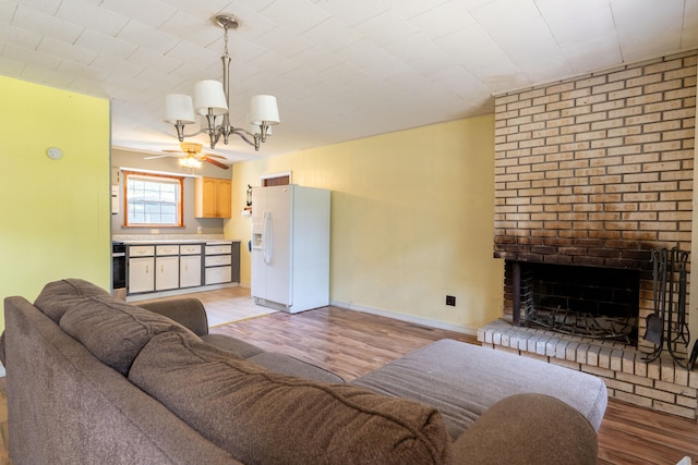 living room featuring ceiling fan, light wood-type flooring, and a brick fireplace