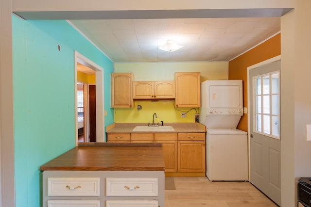 kitchen with stacked washer and clothes dryer, sink, light hardwood / wood-style floors, and light brown cabinets