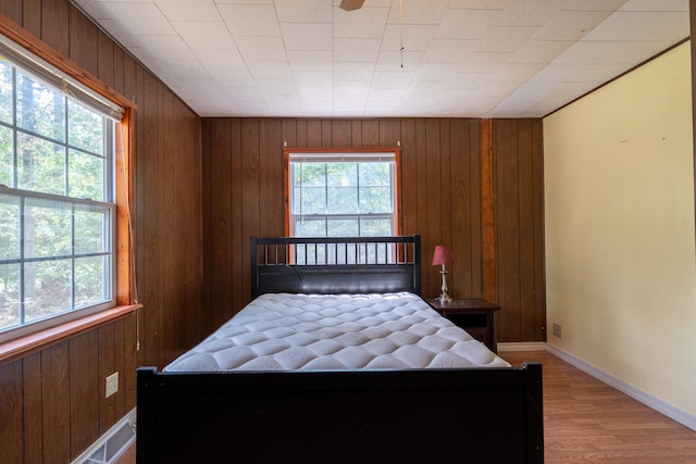 bedroom featuring wooden walls and light wood-type flooring