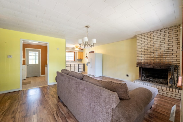 living room with a brick fireplace, hardwood / wood-style floors, and ceiling fan