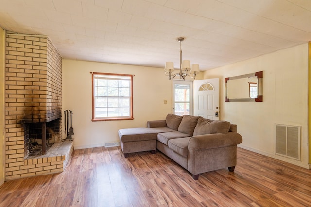 living room featuring a fireplace, a chandelier, and hardwood / wood-style flooring