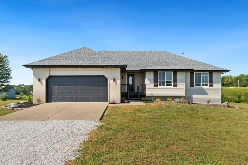 ranch-style house featuring a garage and a front lawn