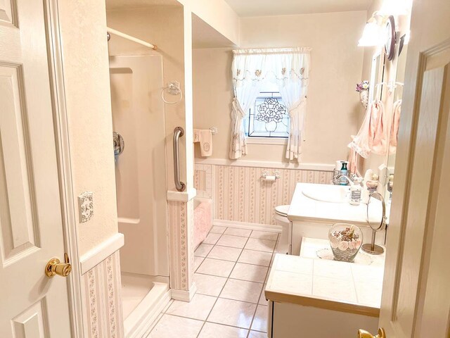 bathroom with wallpapered walls, vanity, tile patterned flooring, and a stall shower