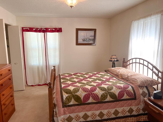 bedroom featuring light carpet and a textured ceiling