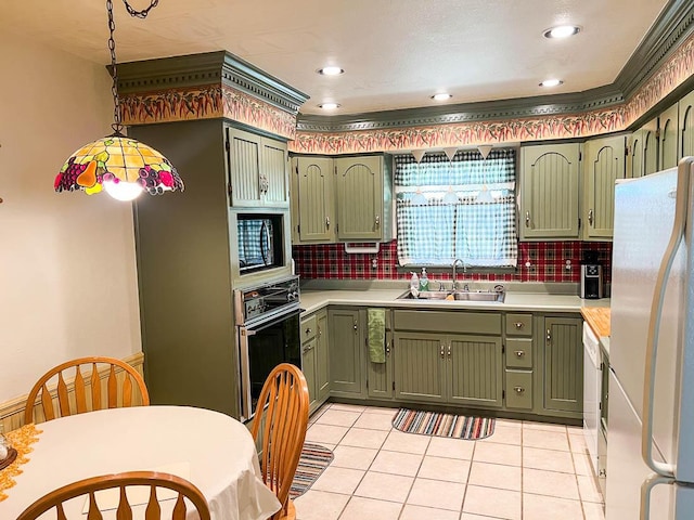 kitchen featuring a sink, black appliances, and green cabinetry