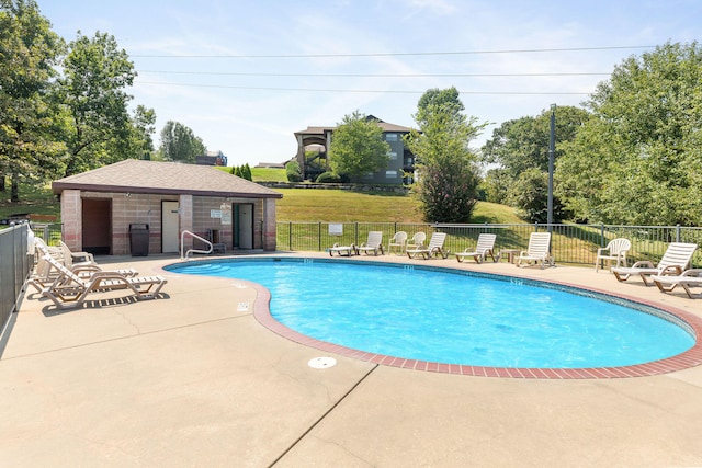 view of pool featuring a patio and a yard