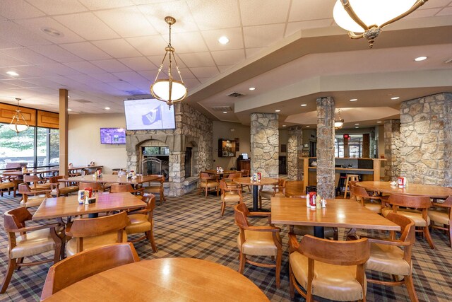 carpeted dining room with recessed lighting, decorative columns, visible vents, and a fireplace