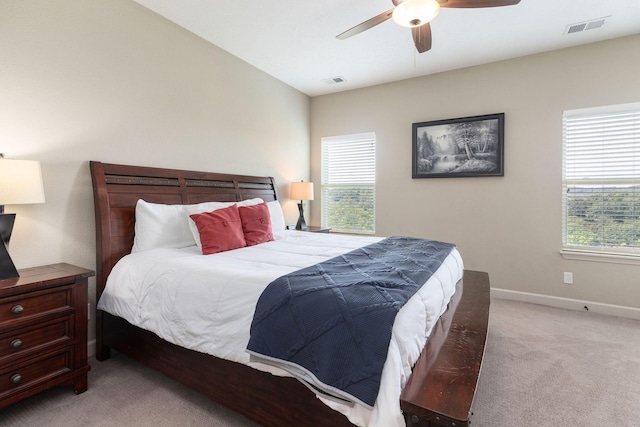 bedroom featuring visible vents, light colored carpet, and multiple windows