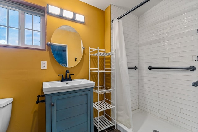 bathroom with walk in shower, vanity, and toilet