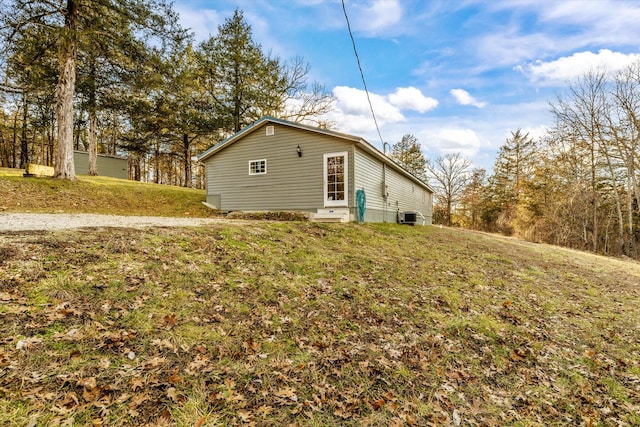 view of side of home featuring a lawn and central AC unit