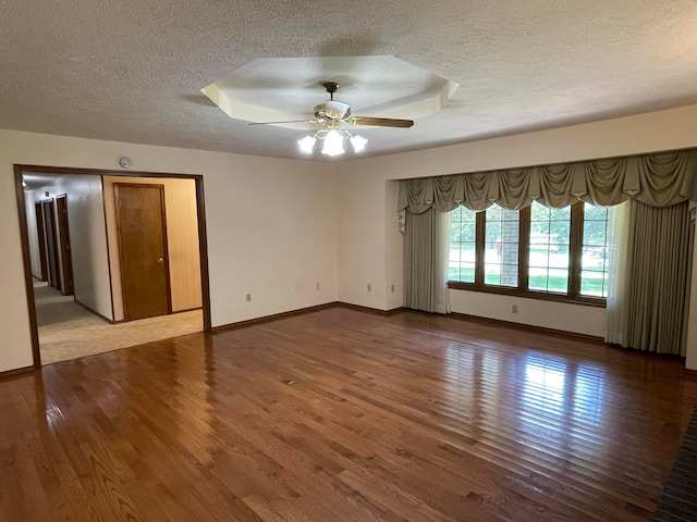 spare room with ceiling fan, hardwood / wood-style flooring, and a textured ceiling