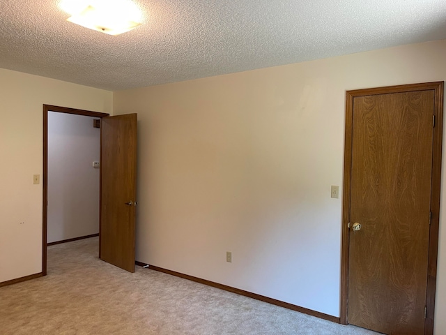 carpeted empty room with a textured ceiling