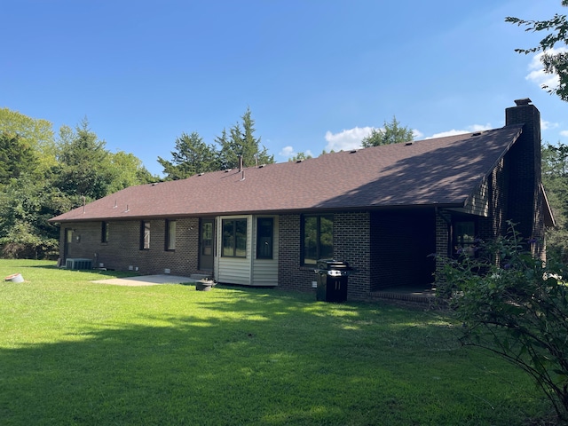 back of property with a patio area, cooling unit, and a lawn