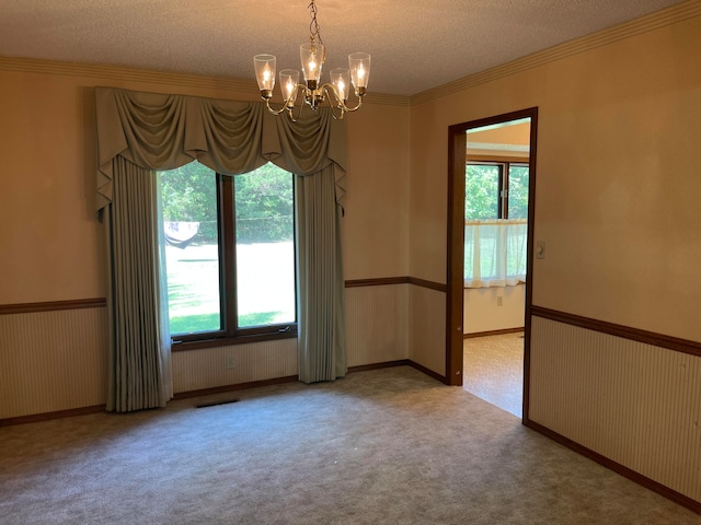 spare room with plenty of natural light, light carpet, a notable chandelier, and a textured ceiling